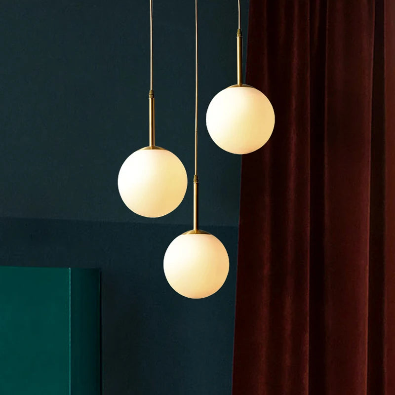 Trois suspensions sous forme de boule en verre blanche - Light Deco